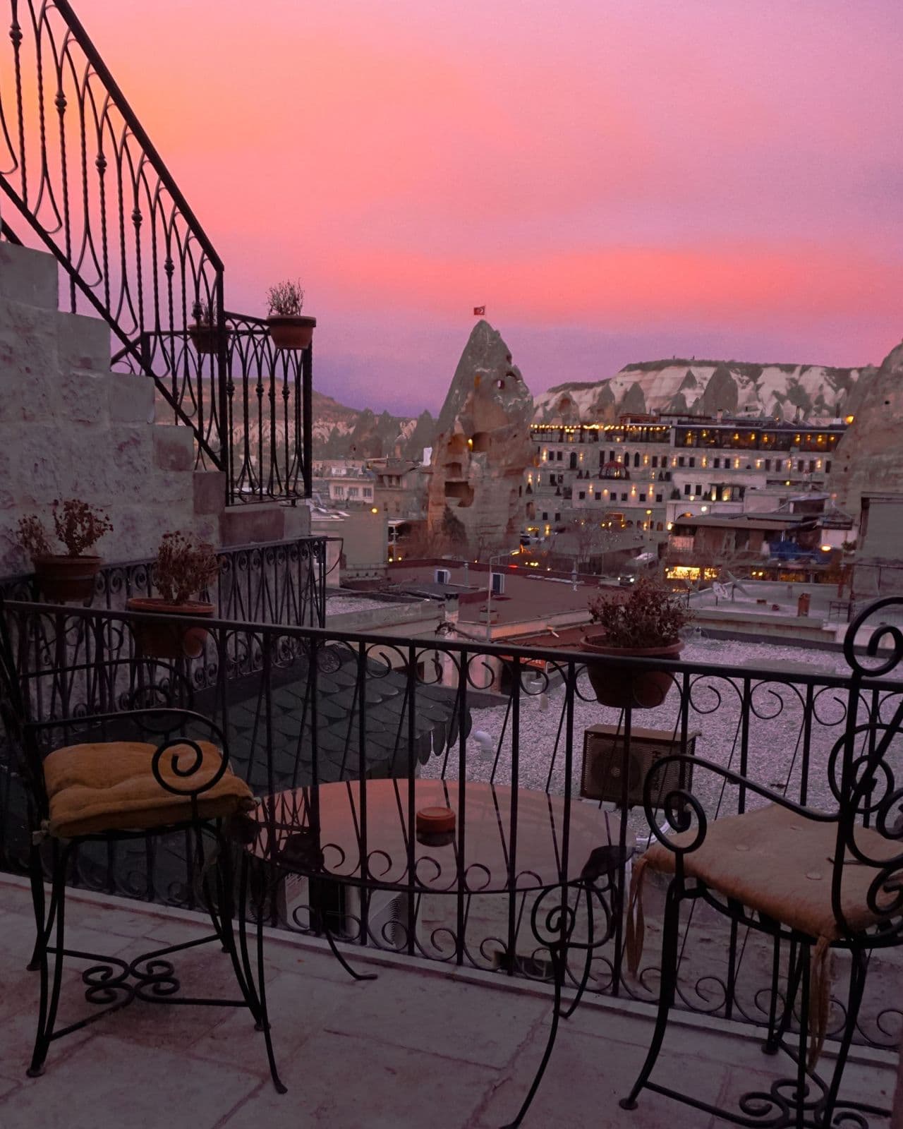 Terraza de un hotel cueva al atardecer con vistas a Göreme, Capadocia
