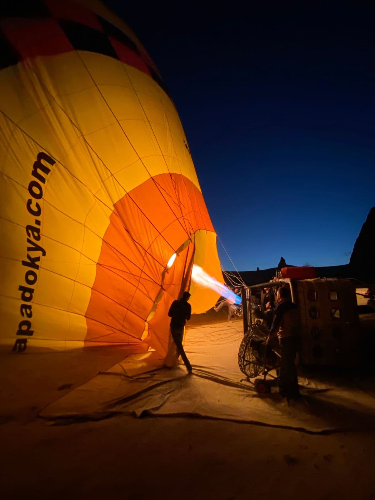 Un globo aerostático inflándose a oscuras antes de un vuelo privado al amanecer